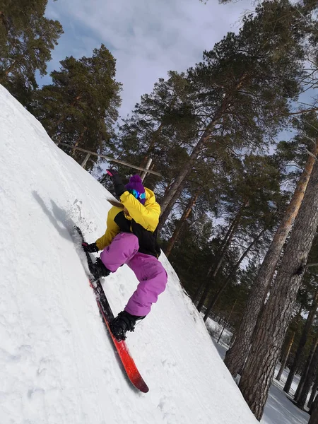 Uma mulher a andar de snowboard. Desportos de Inverno. Menina em engrenagem em um snowboard — Fotografia de Stock