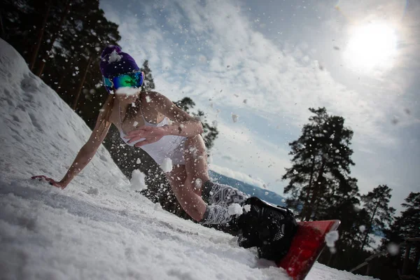Fille vêtue d'un maillot de bain se déplace avec une grande vitesse sur un snowboard. Sport d'hiver — Photo