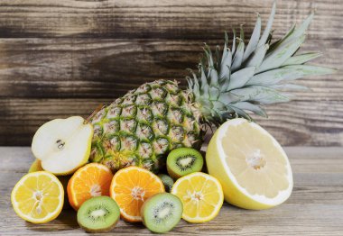ananas ve dilimlenmiş limon, kivi, pamela ve ahşap bir arka plan üzerinde Kazıklı armut