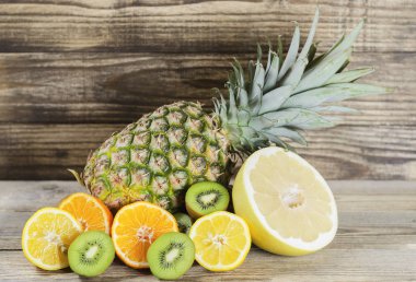 ananas ve dilimlenmiş limon, kivi, pamela ve ahşap 2 bir arka plan üzerinde Kazıklı armut