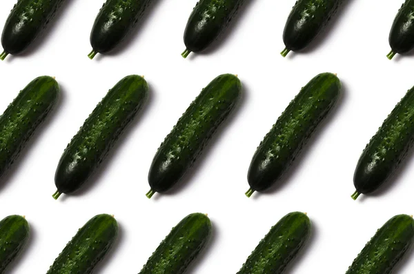 Beyaz arka planda gölgesi olan salatalıklar.