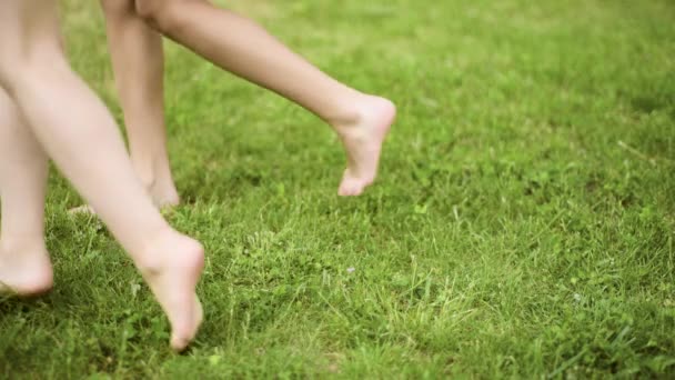 Детские ноги на зеленой траве — стоковое видео