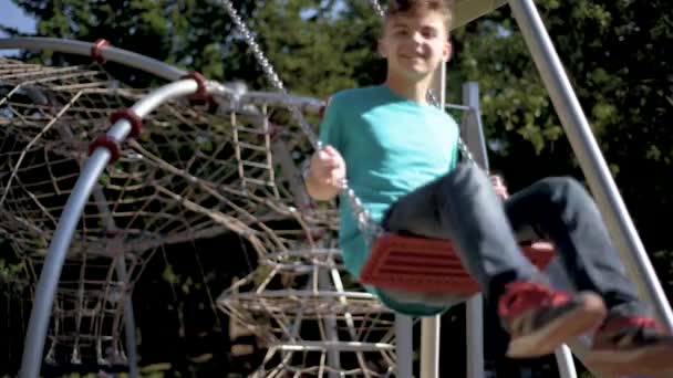 Дети на качелях на детской площадке — стоковое видео