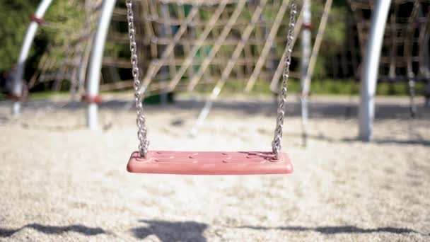 Columpios vacíos en el parque infantil — Vídeo de stock