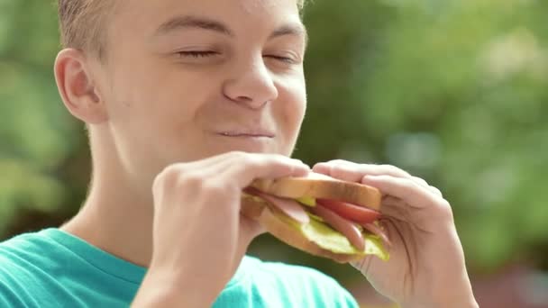 Adolescente menino comer sanduíche — Vídeo de Stock