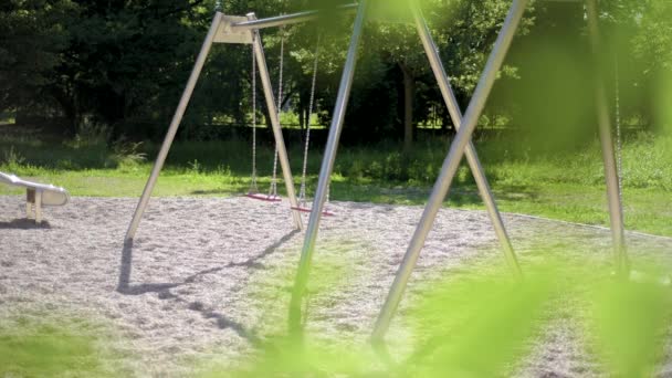 Columpios vacíos en el parque infantil — Vídeos de Stock