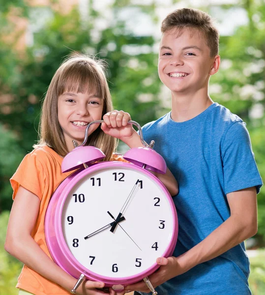 Garçon et fille avec une grande horloge — Photo