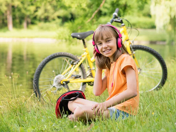 Flicka med hörlurar på park — Stockfoto