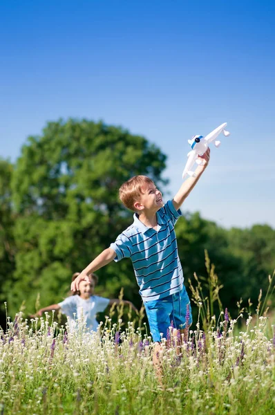 Ευτυχισμένο Αγόρι Και Κοριτσάκι Αεροπλάνο Ένα Λιβάδι Μια Ηλιόλουστη Ημέρα — Φωτογραφία Αρχείου