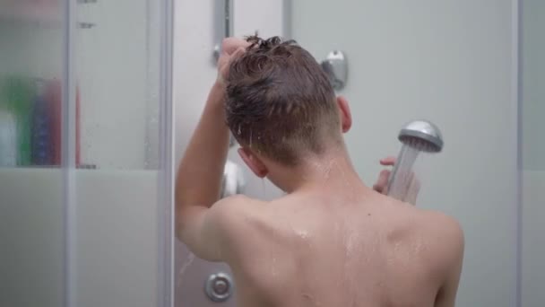 Підліток хлопчик купається під душем — стокове відео