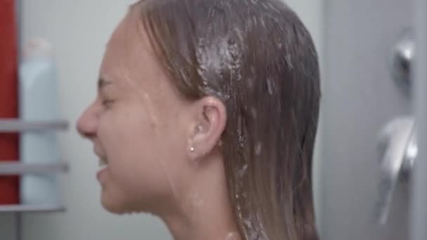 Девочка-подросток купается под душем — стоковое видео