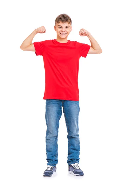 在白色背景查出的年轻高加索青少年男孩全长纵向 穿着红色 T恤衫炫耀他的二头肌的滑稽少年 英俊的孩子显示他的手二头肌强度 — 图库照片