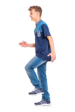 Tam uzunlukta portre genç Beyaz teen çocuğun beyaz arka plan üzerinde izole. Komik genç yürüyüş. Yürüyüş ve gülümseyen yakışıklı etkin alt.