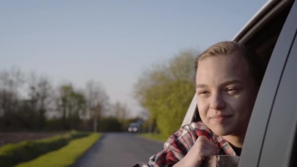 Adolescente regardant par fenêtre de voiture — Video