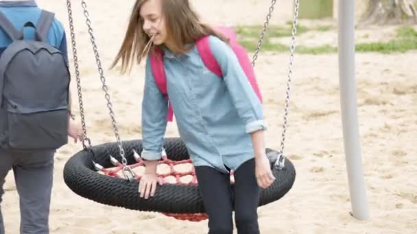 Adolescente ragazzo e ragazza su swing — Video Stock