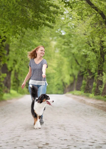 Happy woman with dog on road