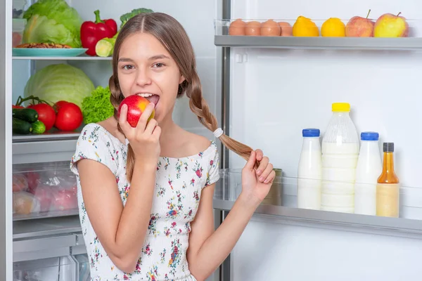 Flicka med mat nära kylskåp — Stockfoto