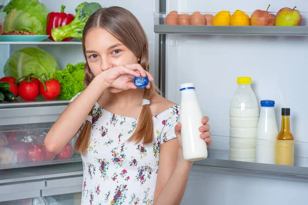 Menina com comida perto da geladeira — Fotografia de Stock