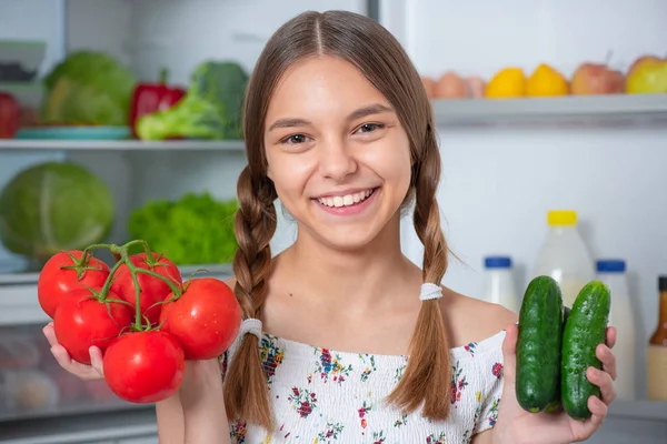 Buzdolabının yanında yemeği olan kız.