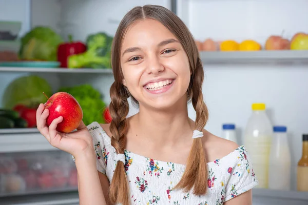 Buzdolabının yanında yemeği olan kız.