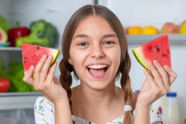 Buzdolabının yanında yemeği olan kız.