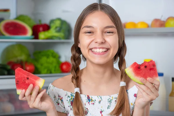 Chica con comida cerca de nevera — Foto de Stock