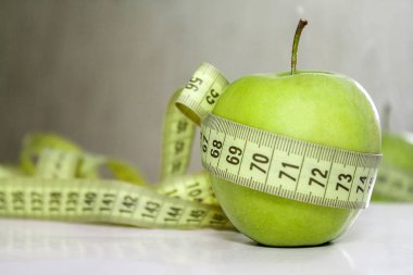 Diyet, sağlıklı beslenme, gıda ve kilo kaybı kavramı. Apple sarılı ölçüm bandı