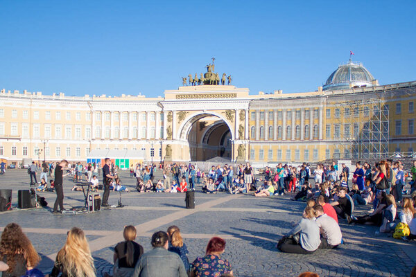 ST. PETERSBURG, RUSSIA - MAY 12, 2018: Street musicians perform for tourists and tips on city center Palace Square. View on Arch of General Staff Triumphal Arch in Saint Petersburg, Russia