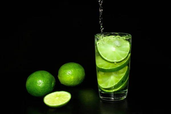 Cold Detox Water Ice Fresh Ripe Slice Green Limes Black — Stock Photo, Image