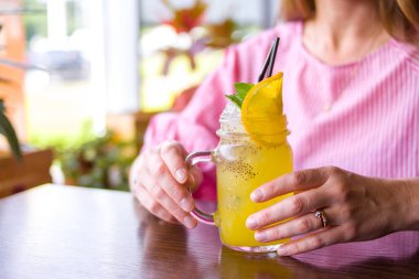 içecekler, insanlar ve yaşam tarzı kavramı - mutlu kadın portakal dilim ile sarı kokteyl café'de içme yakın