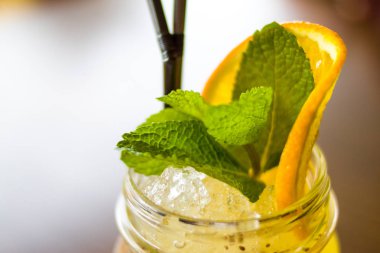 içecekler, insanlar ve yaşam tarzı kavramı - taze tropikal sarı siyah saman bir mason kavanoza Alkolsüz kokteyl portakal ve nane dilim ile dekore edilmiştir.