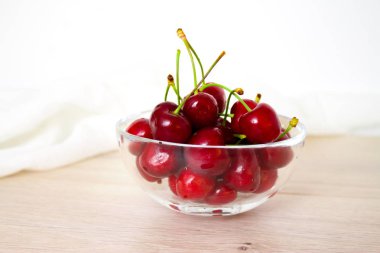 sağlıklı beslenme ve gıda kavramı - kiraz cam çanağı. Kiraz ahşap ve beyaz arka plan üzerinde.