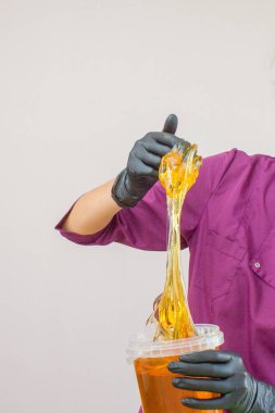 epilasyon ve güzellik kavramı - şeker yapıştırın veya saç Güzellik uzmanı spa salonda siyah eldiven El ile kaldırma için bal balmumu