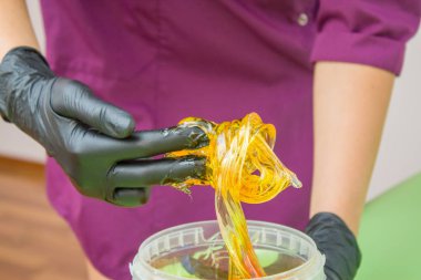 epilasyon ve güzellik kavramı - şeker yapıştırın veya saç Güzellik uzmanı spa salonda siyah eldiven El ile kaldırma için bal balmumu