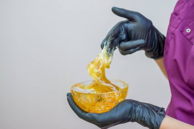 epilasyon ve güzellik kavramı - şeker yapıştırın veya saç Güzellik uzmanı spa salonda siyah eldiven El ile kaldırma için bal balmumu