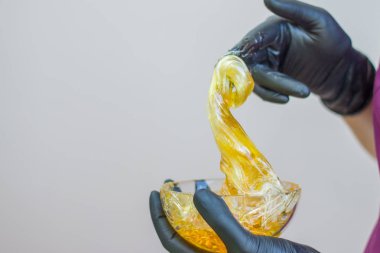 epilasyon ve güzellik kavramı - şeker yapıştırın veya saç Güzellik uzmanı spa salonda siyah eldiven El ile kaldırma için bal balmumu