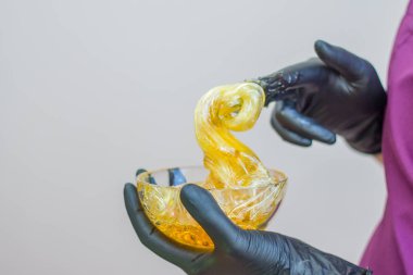 epilasyon ve güzellik kavramı - şeker yapıştırın veya saç Güzellik uzmanı spa salonda siyah eldiven El ile kaldırma için bal balmumu