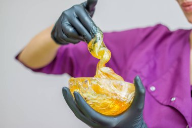 epilasyon ve güzellik kavramı - şeker yapıştırın veya saç Güzellik uzmanı spa salonda siyah eldiven El ile kaldırma için bal balmumu