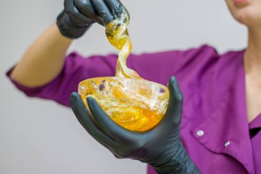 epilasyon ve güzellik kavramı - şeker yapıştırın veya saç Güzellik uzmanı spa salonda siyah eldiven El ile kaldırma için bal balmumu