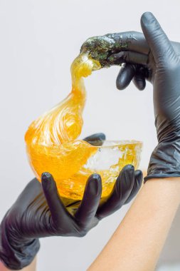 epilasyon ve güzellik kavramı - şeker yapıştırın veya saç Güzellik uzmanı spa salonda siyah eldiven El ile kaldırma için bal balmumu