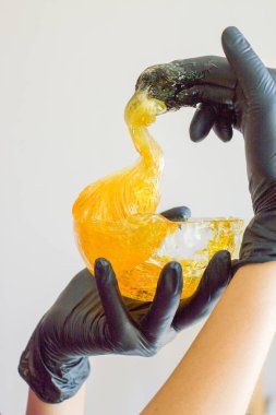 epilasyon ve güzellik kavramı - şeker yapıştırın veya saç Güzellik uzmanı spa salonda siyah eldiven El ile kaldırma için bal balmumu