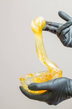 epilasyon ve güzellik kavramı - şeker yapıştırın veya saç Güzellik uzmanı spa salonda siyah eldiven El ile kaldırma için bal balmumu