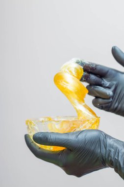 epilasyon ve güzellik kavramı - şeker yapıştırın veya saç Güzellik uzmanı spa salonda siyah eldiven El ile kaldırma için bal balmumu