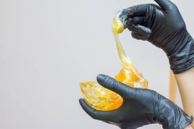 epilasyon ve güzellik kavramı - şeker yapıştırın veya saç Güzellik uzmanı spa salonda siyah eldiven El ile kaldırma için bal balmumu