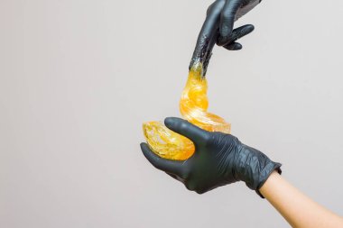 epilasyon ve güzellik kavramı - şeker yapıştırın veya saç Güzellik uzmanı spa salonda siyah eldiven El ile kaldırma için bal balmumu