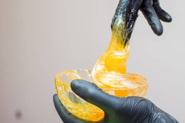 epilasyon ve güzellik kavramı - şeker yapıştırın veya saç Güzellik uzmanı spa salonda siyah eldiven El ile kaldırma için bal balmumu