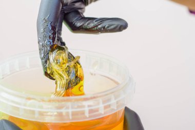 epilasyon ve güzellik kavramı - şeker yapıştırın veya saç Güzellik uzmanı spa salonda siyah eldiven El ile kaldırma için bal balmumu