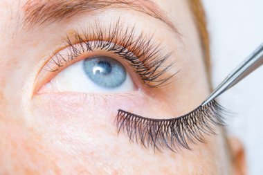 Kirpik Bakımı Tedavi Prosedürleri, Boyama, Curling, Laminasyon ve Kirpikler için Uzatma. Uzun Kirpikli çiller ile Güzellik kırmızı saçlı Model kız. Cilt Bakımı, Spa ve Sağlıklı Yaşam. Yakın çekim.