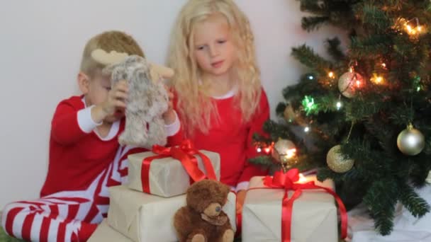 Weihnachts Und Neujahrsgeschenke Kleines Blondes Mädchen Und Junge Roten Pyjama — Stockvideo