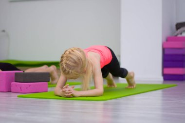 St-Petersburg, Rusya, 6.11.2018: küçük sarışın kız yeşil mat - jimnastik, stretching, yoga kavramı spor salonunda fitness egzersizleri yapıyor